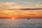 Fishing boat on the background of incredible golden sunrise, clouds and rising sun.