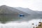 Fishing boat in a calm lake water/old wooden fishing boat/ wooden fishing boat in a still lake water