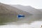 Fishing boat in a calm lake water/old wooden fishing boat/ wooden fishing boat in a still lake water