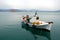 A fishing boat in the harbor at Nafplio in Greece with Bourtzi Castle in the background