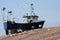 Fishing boat high up shingle bank