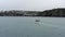 Fishing Boat Motoring at Sea With Tall Cliffs on a Grey Day