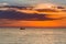 Fishing boat over sunset seacoast skyline