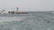 A fishing boat passing by lighthouse