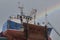 Fishing boat in for repair and painted with rainbow in the background in Freaserbough Harbour, Aberdeenshire, Scotland ,UK 