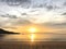 Fishing boat is sailing into the middle of golden sunset light with amazing twilight sky