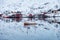 Fishing boat sailing reflection on arctic sea with scandinavian village