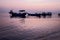 Fishing boat silhouette with orange sunrise sky and water reflection