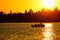 A fishing boat silhouetted against a brilliant orange sky