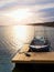 Fishing boat at sunset calm water. A motorboat for sport fishing tied to a wooden pier