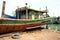 Fishing boat under repair replacing damaged wooden body parts in docks on the riverbank for