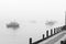 Fishing boats at anchor in harbor and mist