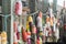 Fishing and boats buoys and beach toys hanging from ropes on a wooden fence.