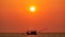 Fishing boats are floating in the Andaman Sea during sunset with golden light of the Sun before sunset and boat background in