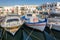 Fishing boats in Naoussa port with traditional Greek houses in background, Paros island,