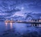 Fishing boats near pier on the sea and snowy mountains at night