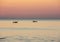 Fishing boats pull their nets at the sunrise. Adriatic cost. Emilia Romagna. Italy