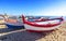 Fishing boats rest on a golden sand beach