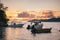 Fishing boats resting in sunset evening light near port of La Digue island, Seychelles. Praslin island on horizon