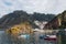 Fishing boats at the sea. Calm water at the natural harbor between cliffs. Small fishing village with white houses built on the