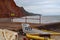 Fishing boats tied up on the jetty at Sidmouth in Devon, England. The River Sid and the red Jurassic cliffs can be seen in the