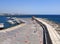 fishing boats and yachts moored along the old Paphos Harbour wall with a view of the beachfront buildings and city in the distance