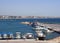 fishing boats and yachts moored in Paphos Harbour with a view of the beachfront buildings and city in the distance