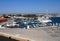 fishing boats and yachts moored in Paphos Harbour with a view of the beachfront buildings and city in the distance