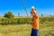 A fishing boy on a river holds a fishing rod, a child caught a fish and pulls it out of the water on a hook