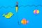 Fishing concept. Colorful toy fish with a hook and fishing buoy on blue background.