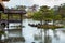 The fishing deck and small islets at the rear of the Golden Pavilion or Rokuon-ji or Kinkaku-ji. Rainy day with falling drops on w
