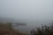 A fishing dock on a dark, foggy, autumn morning by the lake