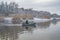 Fishing. Fisherman on inflatable boat with fishing tackle at lake in winter