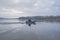 Fishing. Fisherman on inflatable boat with fishing tackle at lake in winter