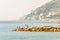 Fishing fishermen standing on rocky marina on Sanremo riviera Liguraian Sea coast with landscaped highland cityscape on the