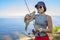 Fishing. Happy fisher girl with walleye zander fish trophy at lake shore