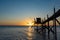 A fishing hut called carrelet with craft lifting net at sunset. Esnandes, charente maritime, France. The sun is caught in the net