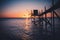 A fishing hut called carrelet with craft lifting net at sunset. Esnandes, charente maritime, France. The sun is caught in the net