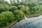 Fishing jetty at a pond with cloud reflections and a forest with