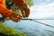 Fishing on the lake. Fisherman hanging a bell on a fishing rod, close-up, selective focus. Special equipment for fishing, bite