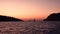 Fishing line, high rocks and Lipari Islands. Sailing boat in Mediterranean sea against horizon. Colorful sky, sunrise or