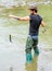 Fishing masculine hobby. Brutal man wear rubber boots stand in river water. Fisher weekend activity. Fisher with fishing