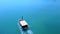 Fishing motorboat sailing on blue tranquil sea. aerial view
