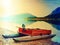 Fishing paddle boat and Upside down paddle boat on bank of Alps lake. Morning lake glowing