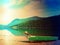 Fishing paddle boat and Upside down paddle boat on bank of Alps lake. Morning lake glowing