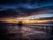 Fishing pier and dock silhouetted in a colorful sunset