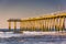 Fishing pier and waves on the Atlantic Ocean at sunrise in Ventnor City, New Jersey.