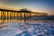 Fishing pier and waves on the Atlantic Ocean at sunrise in Ventnor City, New Jersey.