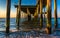 Fishing pier and waves on the Atlantic Ocean at sunrise in Ventnor City, New Jersey.