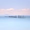 Fishing poles and soft water on sea landscape. Long exposure.